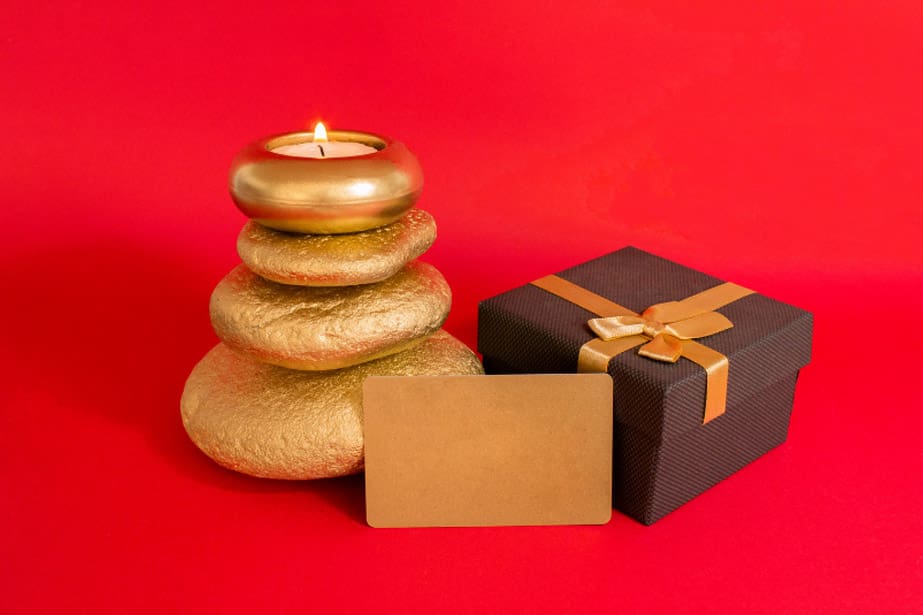 A candle and some rocks are next to a gift.