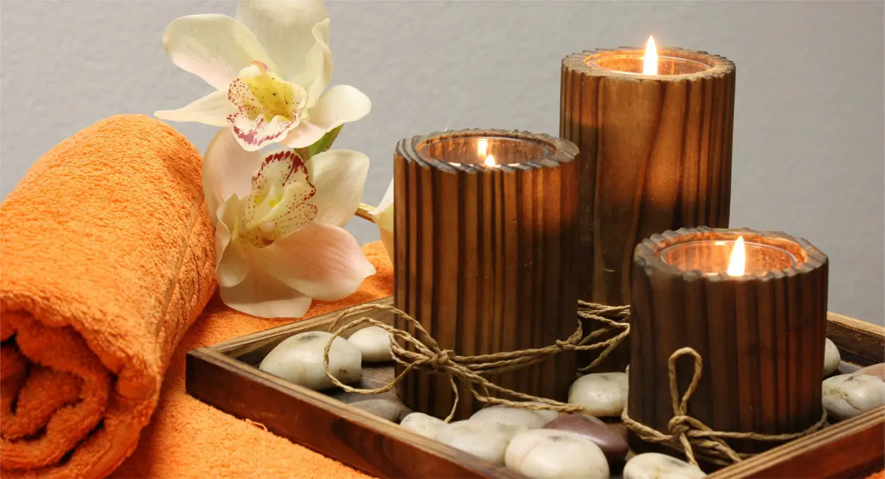 Candles and flowers on a tray with brown wooden candle holders.