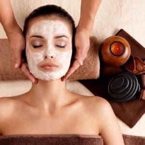 A woman getting her face washed with clay